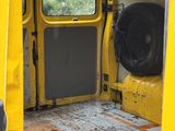 a yellow van that has a tire in the back of it