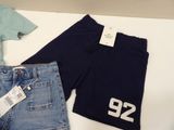 two pairs of shorts and a t - shirt on a table