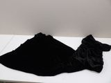 a black dress laying on a white table in a room