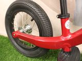 a red bike with a black tire on the grass