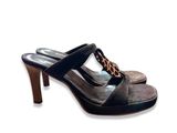 Cette femme porte une paire de chaussures dont le talon est orné d'une chaîne.