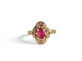 a close up of a gold ring with a ruby stone