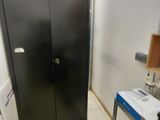 a black cabinet in the corner of a room with tools on it