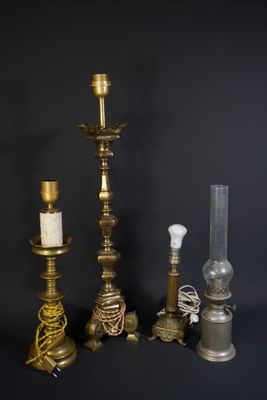 trois bougies en laiton et une lampe en verre sur fond noir
