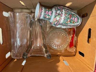 une boîte en carton contenant tout un tas d'objets en verre