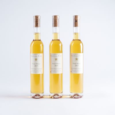 trois bouteilles de vin posées les unes à côté des autres sur une surface blanche