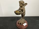une petite statue représentant un petit garçon tenant un panier