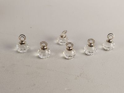 un lot de cinq perles en verre transparent munies d'œillets en argent