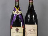 two bottles of wine sitting on top of a table next to each other