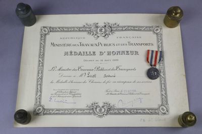 un vieux document sur lequel repose une médaille, et une autre médaille posée dessus