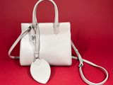 a white purse with a tag on it on a red background