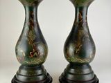 une paire de vases verts ornés de motifs sur fond blanc