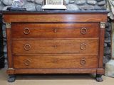 une commode en bois surmontée d'un tableau