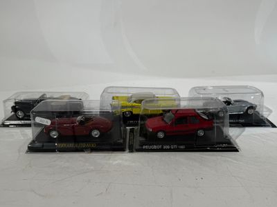 three toy cars in a display case on a white surface