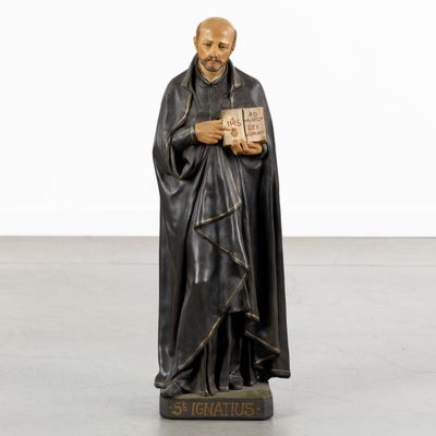 a statue of a man holding a book in his hands