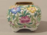 a white vase with colorful flowers on it sitting on a table