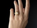 main d'une femme portant une bague en or sertie d'une pierre blanche