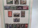 an open book with a bunch of stamps on it sitting on a table