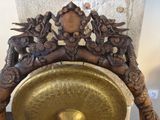 a golden bell sitting on top of a wooden chair