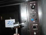 a hand that is holding a sign in front of an oven