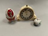 a clock and two eggs sitting next to each other on a table