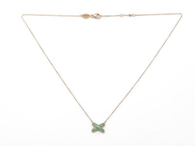 un collier en or avec un pendentif en forme de papillon vert au bout d'une chaîne