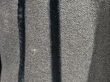 the back of a black and grey jacket with gold buttons