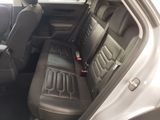 the back seats of a car with a remote control in the passenger seat
