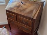 a small wooden desk with a lamp on top of it