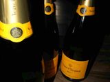 three bottles of champagne sitting on a wooden table