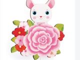une image représentant une poupée en papier en forme de lapin avec des fleurs