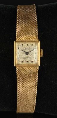 une image représentant une montre-bracelet en or avec un bracelet maillé