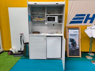 une petite cuisine équipée d'un réfrigérateur et d'un micro-ondes