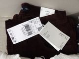 a box with a pair of brown pants and a pair of white tags
