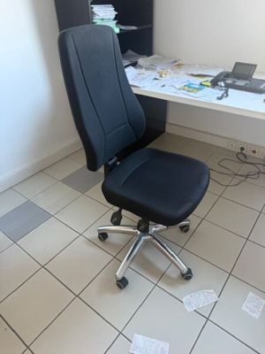 une chaise de bureau noire assise devant un bureau blanc