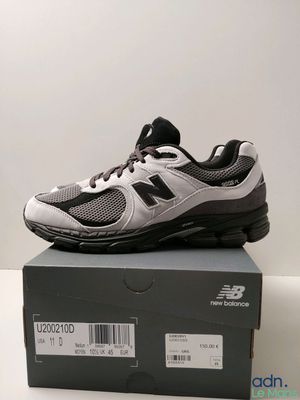 Les chaussures New Balance sont dans la boîte posée sur la table.