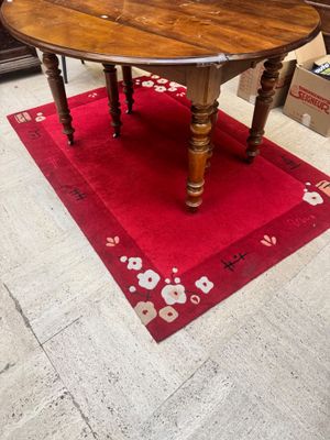 une image représentant une table avec un tapis rouge posé au sol