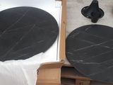 two black plates sitting on a table next to a lamp