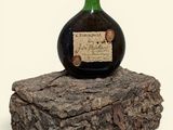 a bottle of wine sitting on top of a piece of wood