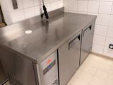 a stainless steel counter top in a kitchen with a microwave