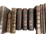 plusieurs vieux livres sont alignés sur une surface blanche