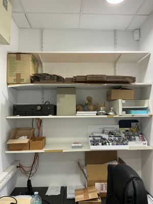 une pièce contenant un bureau, des étagères et une chaise
