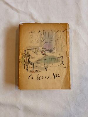 un vieux livre sur lequel figure le dessin d'une femme assise sur un lit