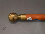 a wooden stick with a brass ball on top of it