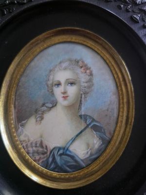 painting of a woman in a blue dress in a gold frame