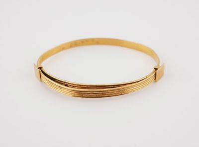 a close up of a gold bracelet on a white background