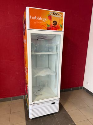 un réfrigérateur qui se trouve dans le coin d'une pièce