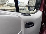 a cat that is sitting in the passenger seat of a car