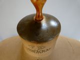 a brown vase with a wooden top on a table