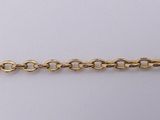 a close up of a gold chain on a white surface